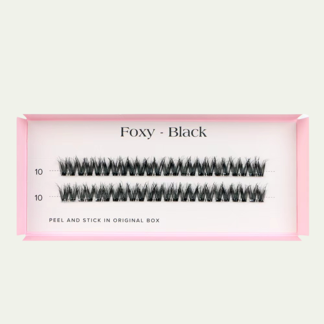 Faux eyelashes in a pink packaging box on a light beige background