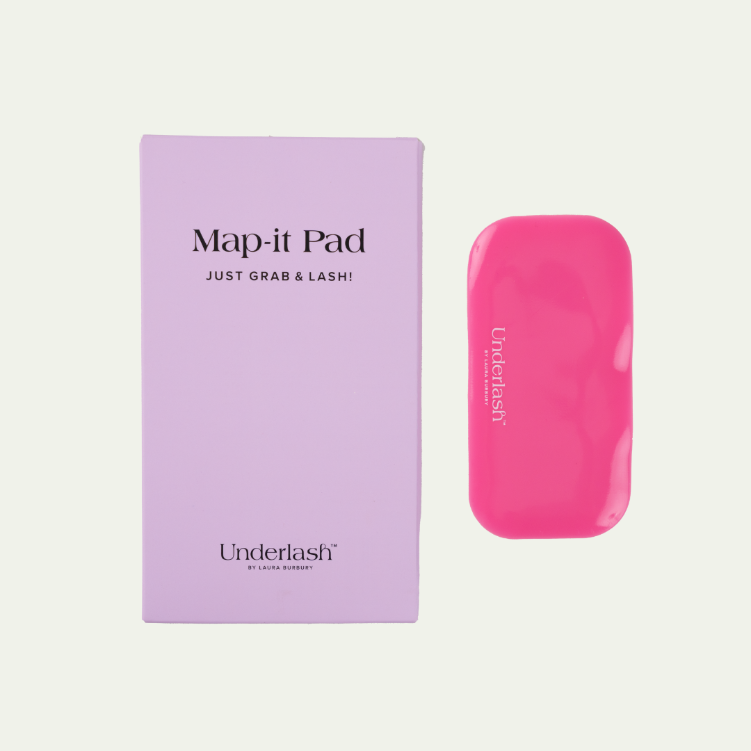 A pink silicone lash mapping pad with the brand Underlash's logo and the product name 'Map-It Pad' displayed next to its purple packaging.