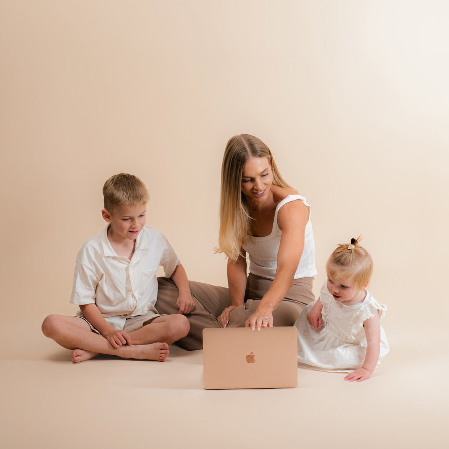 Laura working on her laptop with her two children