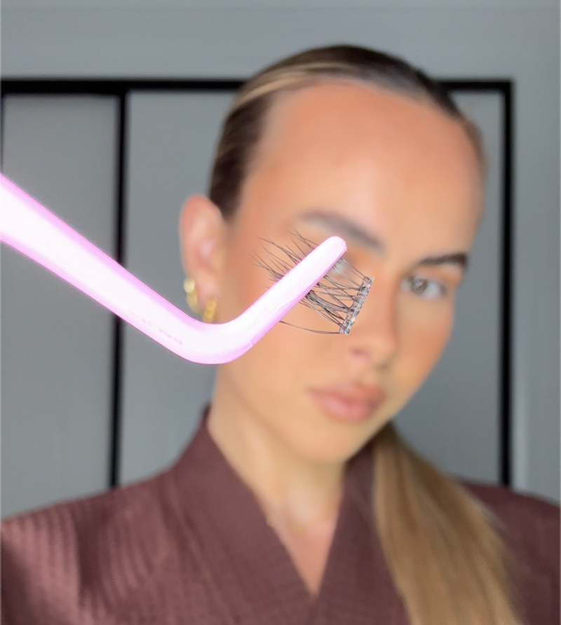Lifting a pre-glued Quickies lash from the tray