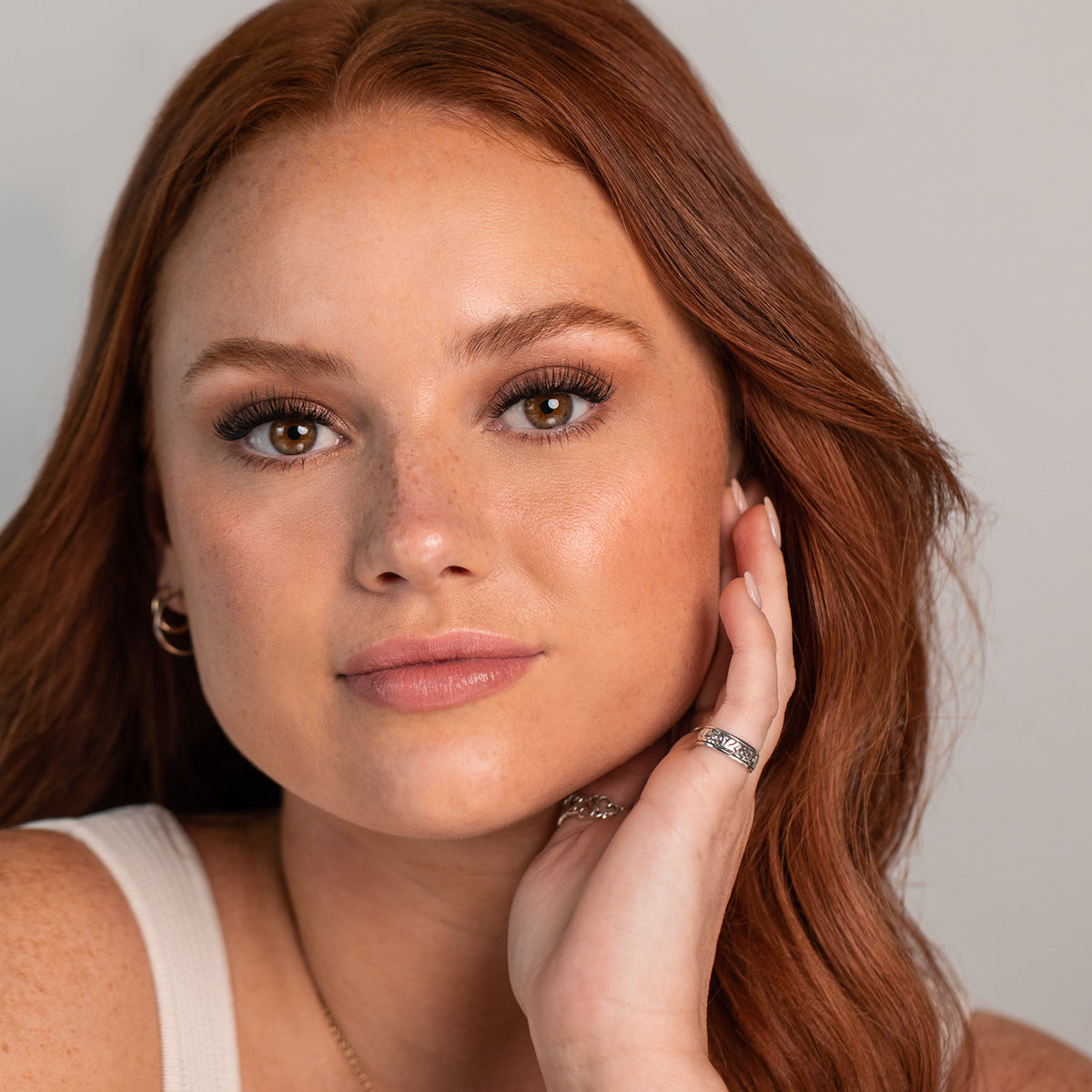 Picture of a beautiful red headed girl with freckles wearing Underlash by laura Burbury lash extensions in the style mood length 12/14mm 